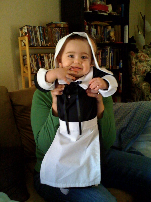 A little baby dressed up as a woman pilgrim